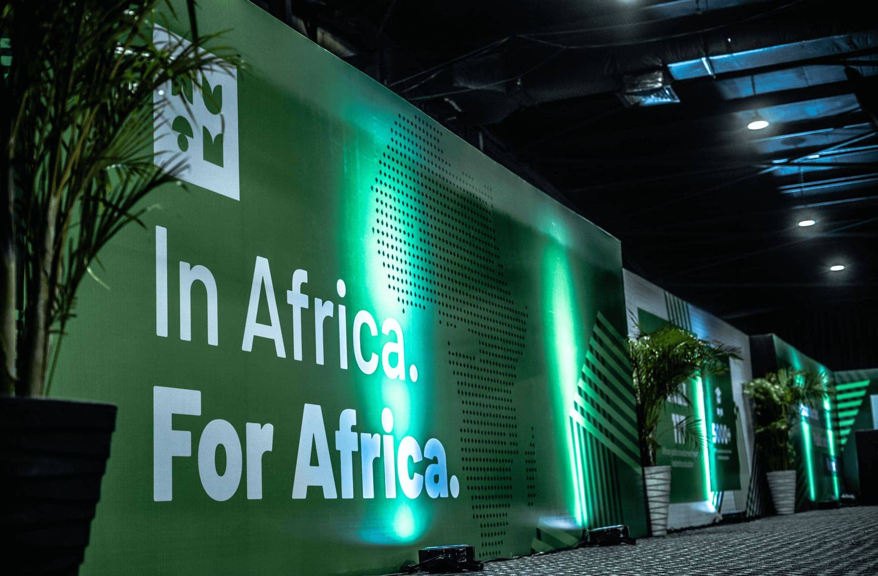 An illuminated wall reading In Africa. For Africa.